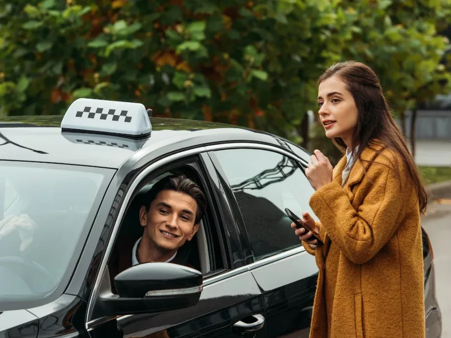 Chauffeur in de taxi maakt een praatje met een klant