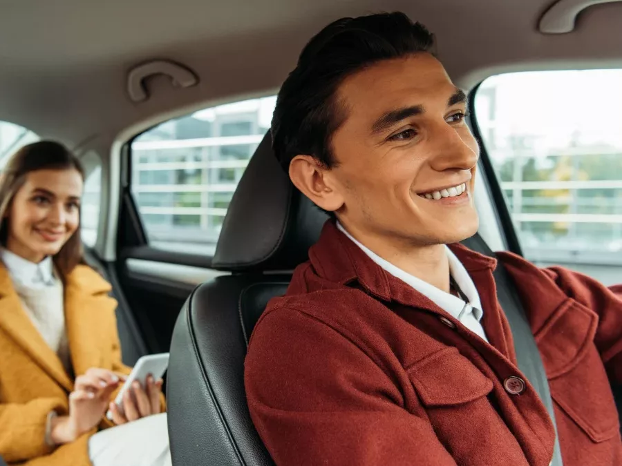 Chauffeur en passagier onderweg in de taxi naar Schiphol