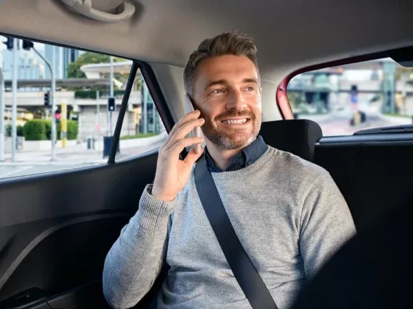 Passagier belt ontspannen achterin de taxi